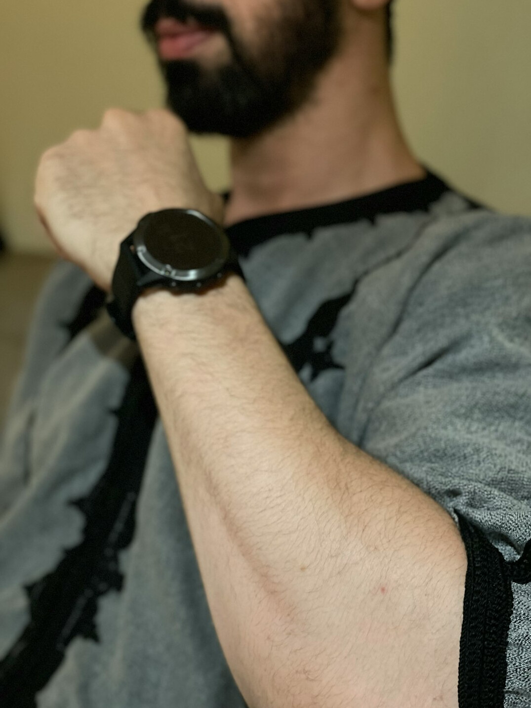 Portrait of a man with short dark hair and a beard in a casual shirt