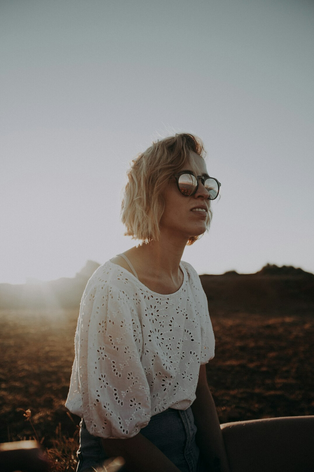 Portrait of a woman with short blonde hair smiling in natural light